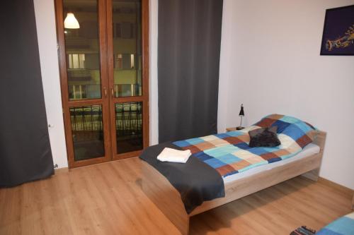 a bedroom with a bed with a plaid blanket at Apartament Sienkiewicza 8 in Zamość