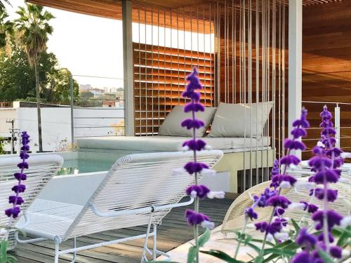 a group of chairs and purple flowers on a porch at Sisao Hotel-Café in Cuernavaca
