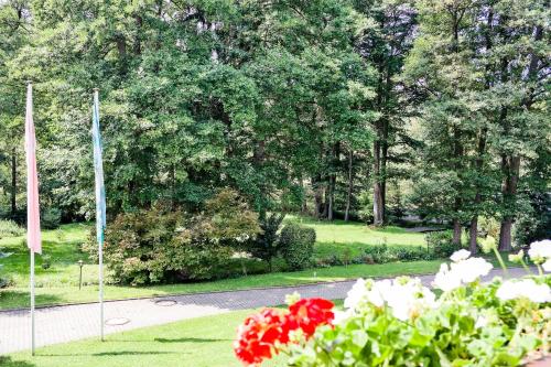 a view of a park with flowers and a flag at Hotel Vogtland in Bad Elster