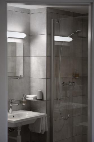a bathroom with a shower and a sink at Auberge du Prévoux in Le Locle