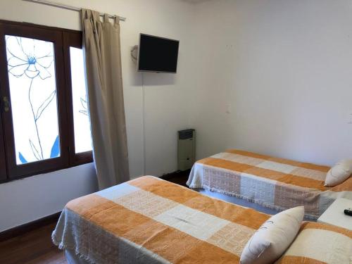 a hotel room with two beds and a window at Departamento zona residencial CON PILETA in Salta