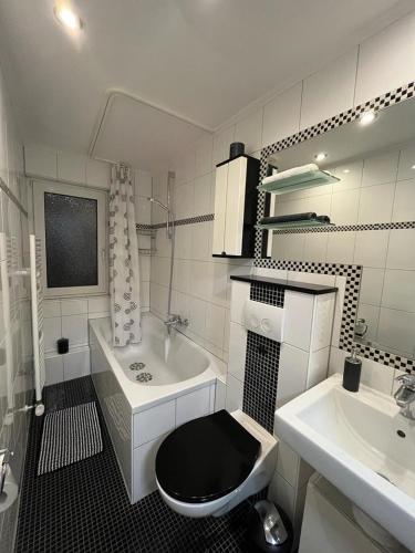 a bathroom with a black toilet and a sink at Casa Arturo Düsseldorf - Flughafen, Messe und City 3 km in Düsseldorf