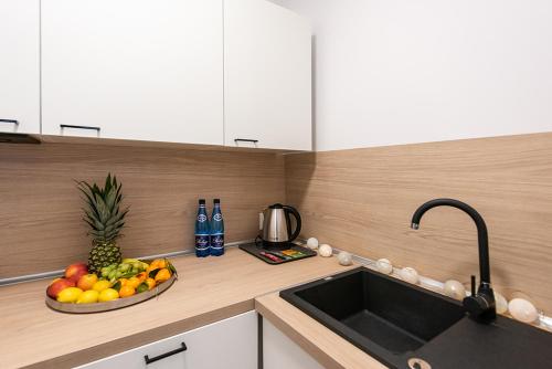 a kitchen with a sink and a bowl of fruit at Apartamenty Centrum II in Bydgoszcz