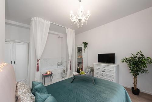 a bedroom with a bed and a tv and a chandelier at Apartamenty Centrum II in Bydgoszcz