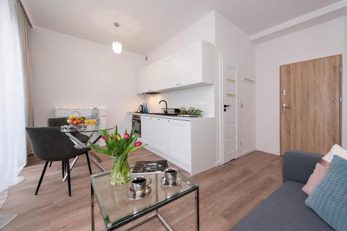a living room with a couch and a table and a kitchen at Apartamenty Centrum II in Bydgoszcz