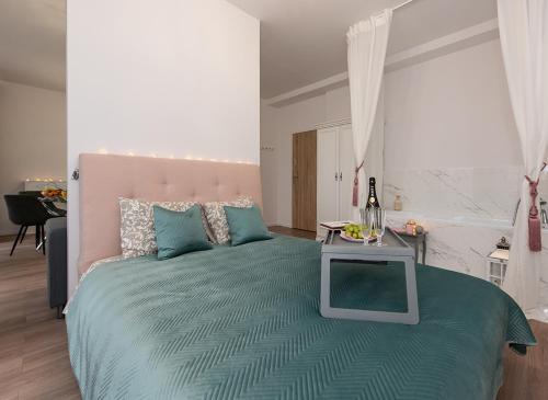 a bedroom with a large bed with a table on it at Apartamenty Centrum II in Bydgoszcz