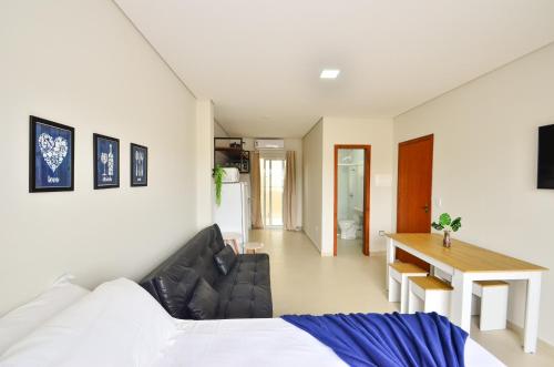 um quarto com uma cama, uma mesa e uma secretária em InHome - Estúdio 02, conforto e aconchego no Campeche N1518 em Florianópolis