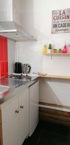 a kitchen with white cabinets and a counter top at CosyStudio Site du Futuroscope in Chasseneuil-du-Poitou
