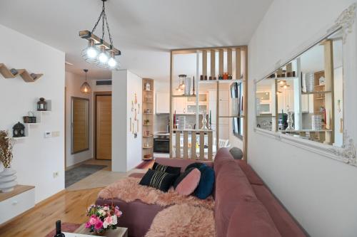 a living room with a brown couch and a kitchen at Apartman Tea - Zlatibor in Zlatibor