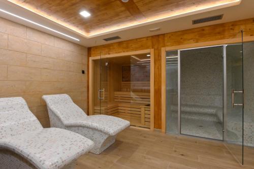 two chairs in a room with a glass shower at Apartman Tea - Zlatibor in Zlatibor