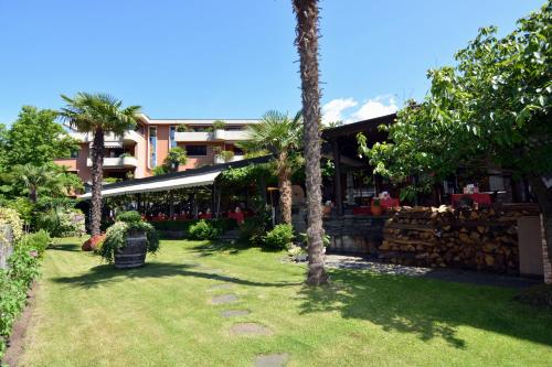 a yard with palm trees and a building at Garni degli Angioli in Ascona
