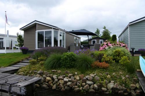 einen Garten mit einer Bank und Blumen vor einem Haus in der Unterkunft Watervriend in Earnewâld