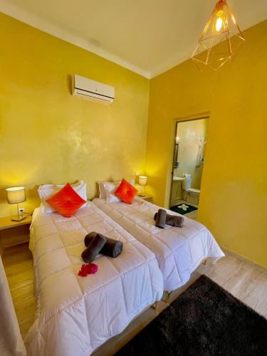 a bedroom with a large white bed with red pillows at Villa Kesh Evasion Marrakech in Marrakech