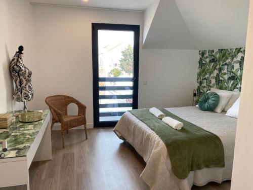 a bedroom with a bed and a desk and a window at Seixal Old Town River View Apartment in Seixal