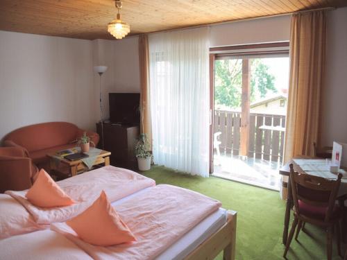 1 Schlafzimmer mit 2 Betten, einem Schreibtisch und einem Fenster in der Unterkunft Landhaus Harmonie in Arnbruck