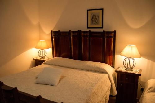 a bedroom with a large bed with two lamps at I Trulli degli Ulivi in Locorotondo