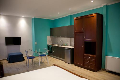 a kitchen with a table and a blue wall at Villa Niki in Plataria