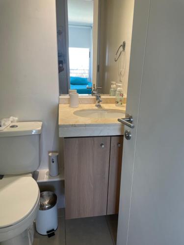 a bathroom with a sink and a toilet and a mirror at Edificio En Reñaca in Viña del Mar