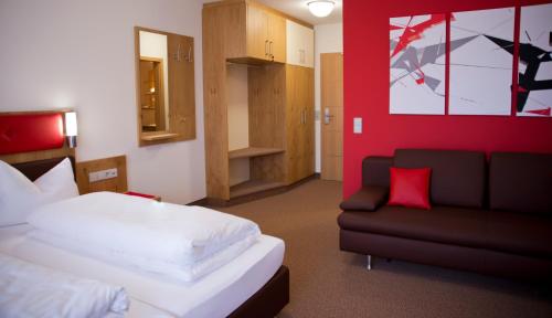 um quarto de hotel com uma cama e um sofá em Hotel Restaurant zur Windmühle em Ansbach
