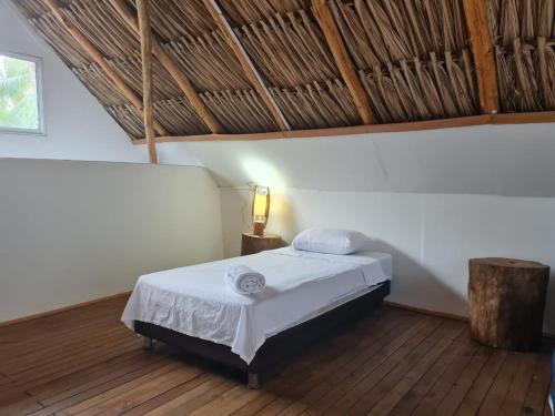 a bedroom with a bed and a wooden floor at Hotel Playa Mandala in Palomino