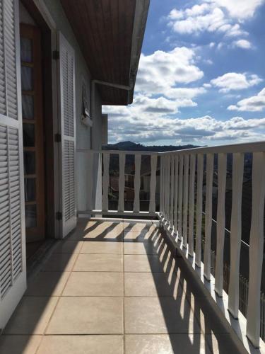 a balcony of a house with a view of the ocean at Suítes Refúgio do Sossego - Campos do Jordão in Campos do Jordão
