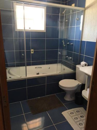 a bathroom with a tub and a toilet and a sink at Suítes Refúgio do Sossego - Campos do Jordão in Campos do Jordão