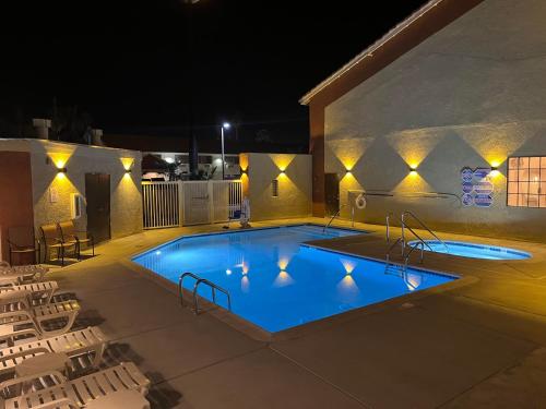 a swimming pool at night with chairs around it at Quality Inn Blythe I-10 in Blythe