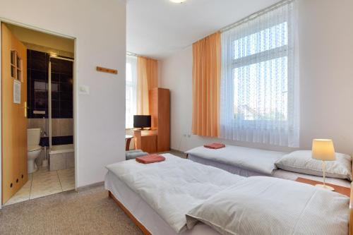 1 dormitorio con 2 camas y baño en Hotel Stary Ratusz, en Kostomłoty