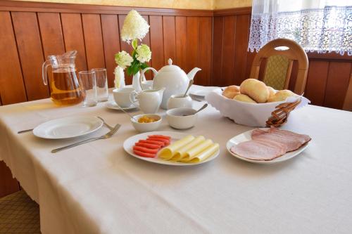 a table with a white table cloth with food on it at Hotel Stary Ratusz in Kostomłoty