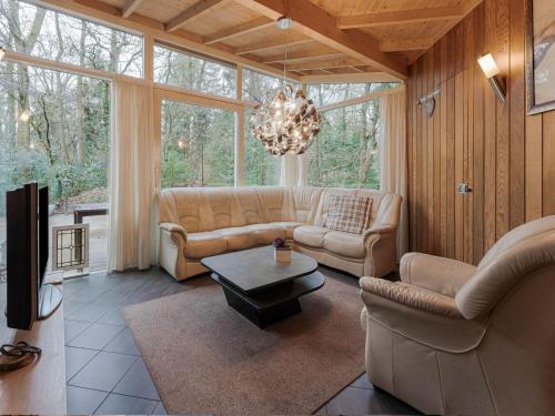 uma sala de estar com sofás e um lustre em Idyllically located Holiday Home in Norg with Sauna em Norg