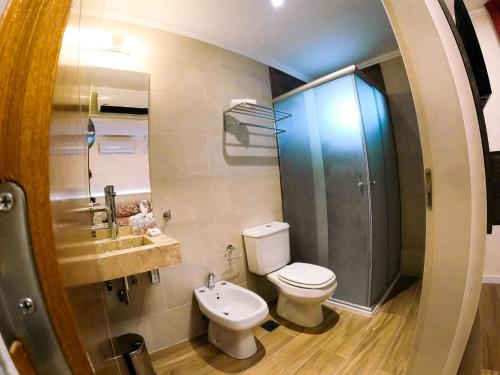 une salle de bain avec toilettes et lavabo dans l'établissement Hotel Majestic, à Villa Giardino