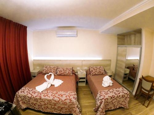 Cette chambre d'hôtel comprend 2 lits avec des arcs. dans l'établissement Hotel Majestic, à Villa Giardino