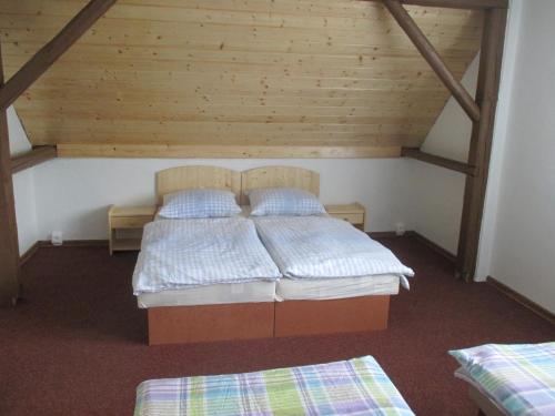 NejdekにあるDům Hanaのベッドルーム(ベッド2台付)が備わる屋根裏部屋です。