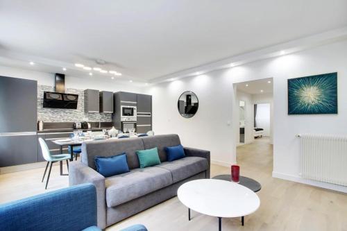 a living room with a couch and a table at TROCADERO/ EIFFEL TOWER - 3 Bedrooms- All New! in Paris