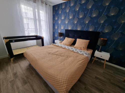 une chambre avec un grand lit et un mur bleu dans l'établissement ***Suite Régence * 5min Disney & Shopping * NEW***, à Serris