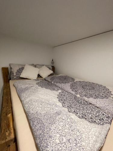- un grand lit avec une couverture dans l'établissement Bergglück - gemütliches Appartement am Traunsee, à Altmünster