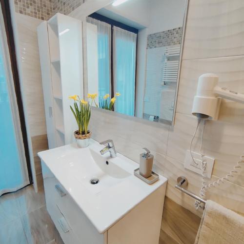 a bathroom with a white sink and a mirror at CASA VACANZE DA MARTI in Tirano