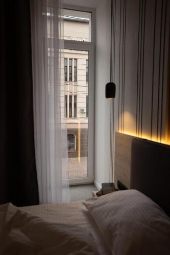 a bedroom with a bed and a window with a building at Kulikovskiy hotel in Kharkiv