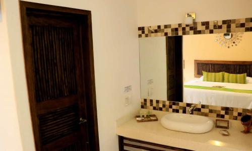 a bathroom with a sink and a mirror and a bed at Casa Mandala Hotel in Pijijiapan