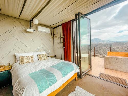 a bedroom with a bed and a balcony with a view at Native Residence in Rosarito