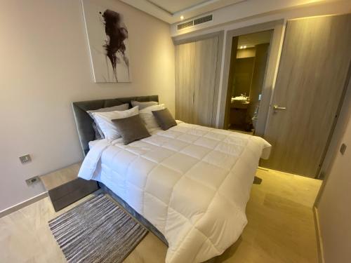 ein Schlafzimmer mit einem großen Bett mit weißer Bettwäsche in der Unterkunft Très beau studio à Ain Diab in Casablanca