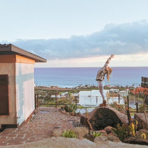 a person standing on a rock in front of the ocean at Native Residence in Rosarito