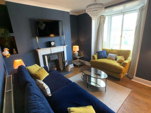 sala de estar con sofá azul y chimenea en Superb House in Looe, Near Beach and Bars with Great Views and free access to a nearby Indoor Swimming Pool, en Looe