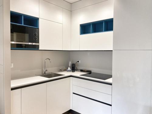 a kitchen with white cabinets and a sink at Borgomarino 32 in Pescara