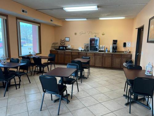 a restaurant with tables and chairs and a counter at Travelers Lodge Beatrice in Beatrice