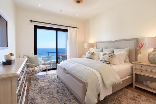 a bedroom with a bed with a view of the ocean at Beachfront Flats Los Cabos in San José del Cabo
