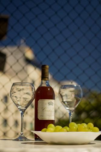 two glasses and a bottle of wine and a plate of grapes at Maravilhoso apartamento de 2 quartos com vista mar in Cabo Frio