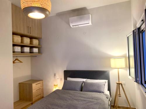 a bedroom with a bed with blue pillows at Crete Garden Guesthouse in Agios Nikolaos