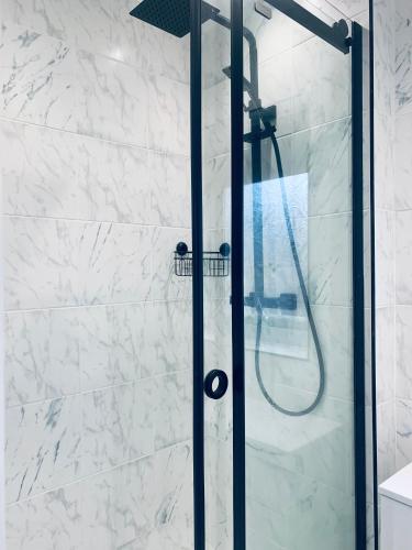 a shower with a glass door in a bathroom at Comfortable 3 bed residential home in Sheffield in Sheffield