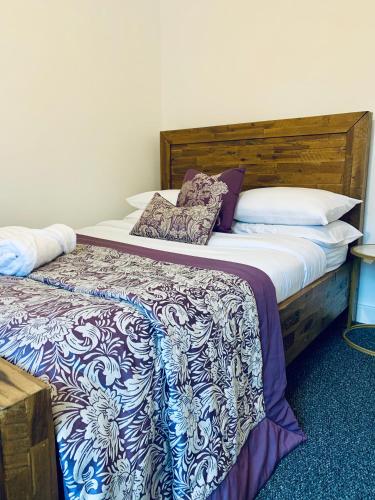 a bedroom with a large bed with a blue and white blanket at Comfortable 3 bed residential home in Sheffield in Sheffield